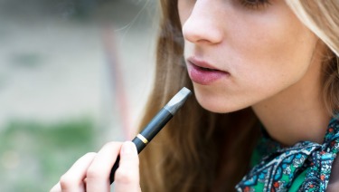 Teen girl using an e-cigarette.