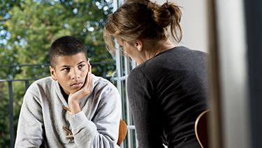 Woman speaking with adolescent.