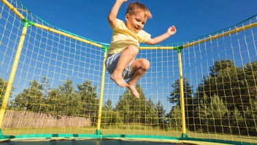 boy jumping on trampoline