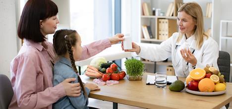 parent with their child asking doctor about vitamin supplements for kids