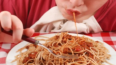 Child eating pasta. 