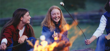 a group of women sitting around a fire