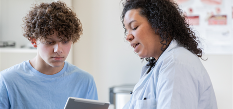 a person and a boy looking at a tablet