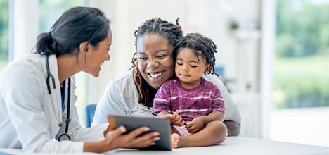 A happy baby laughing during a first vaccination appointment